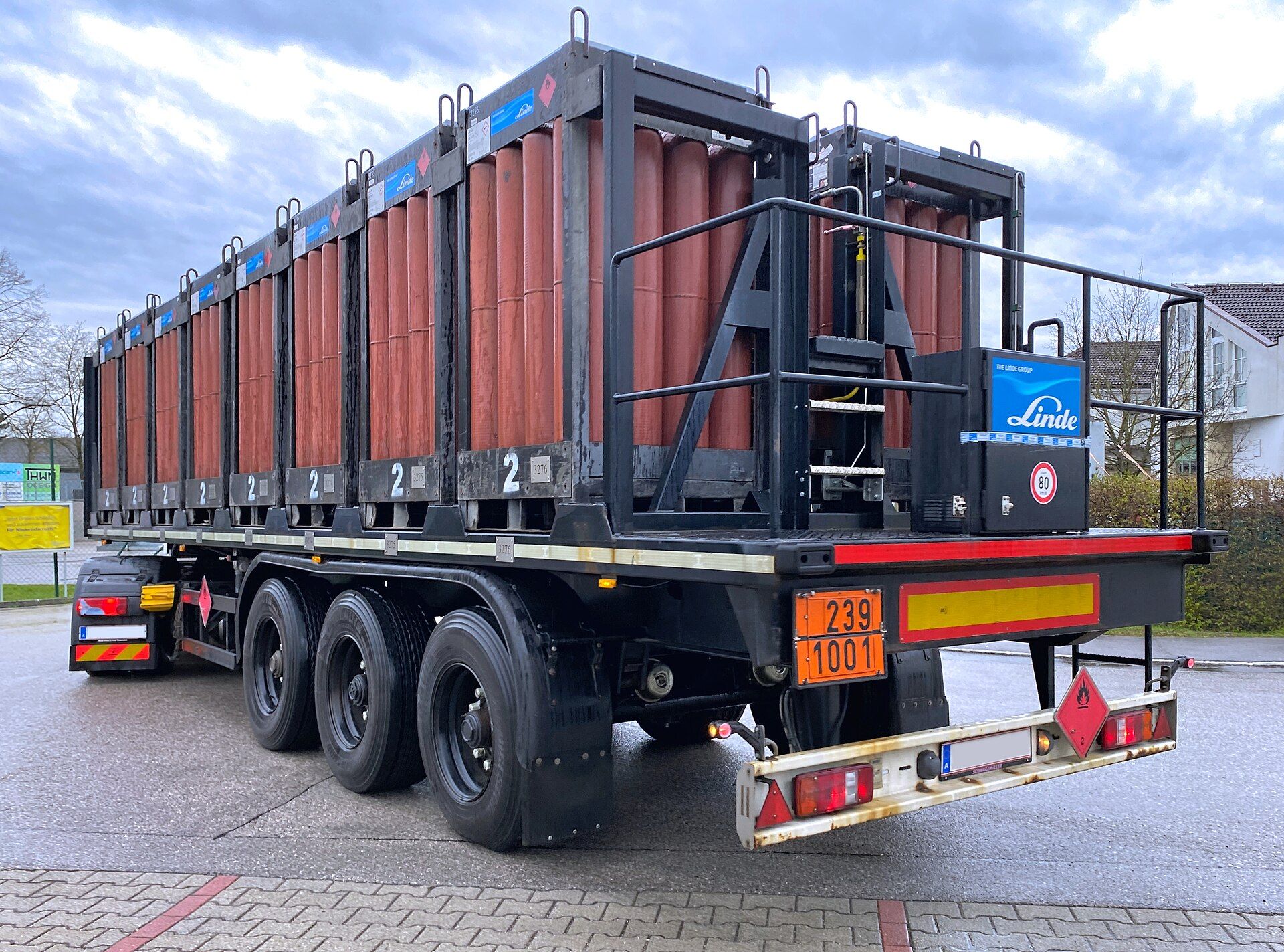 Three-axle semi-trailer loaded with gas cylinder bundles, carrying an orange ADR plate reading 239 over 1001 at the rear