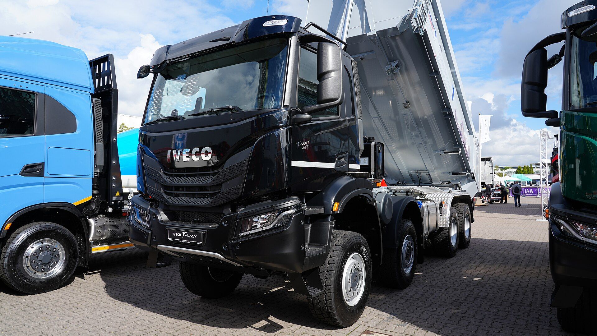 Black Iveco T-Way four-axle tipper with its body raised, on display at IAA Transportation 2022