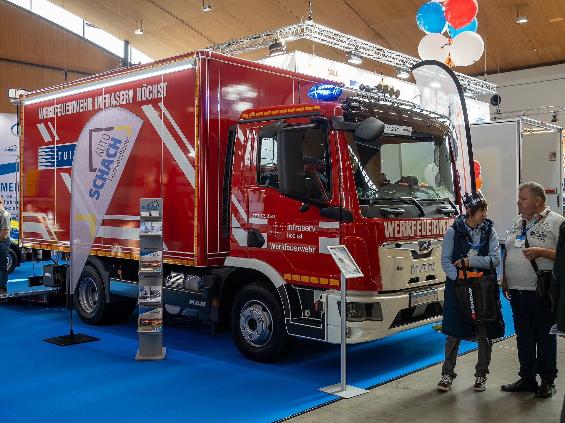 Red MAN TGL 12.250 rigid with a works fire brigade box body, on a trade fair stand at Nufam 2025 in Rheinstetten