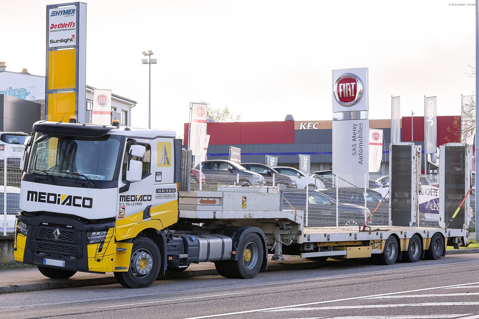 Nooteboom three-axle semi low loader coupled to a Renault Trucks C 480, ramps stowed upright at the rear