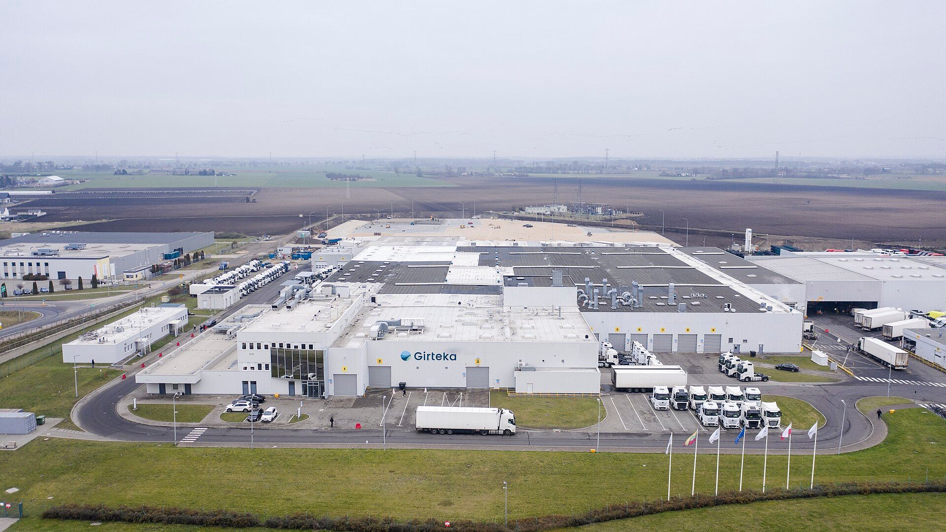 Aerial view of a road haulage operator's base in Poland, with tractor units and semi-trailers parked beside the warehouse