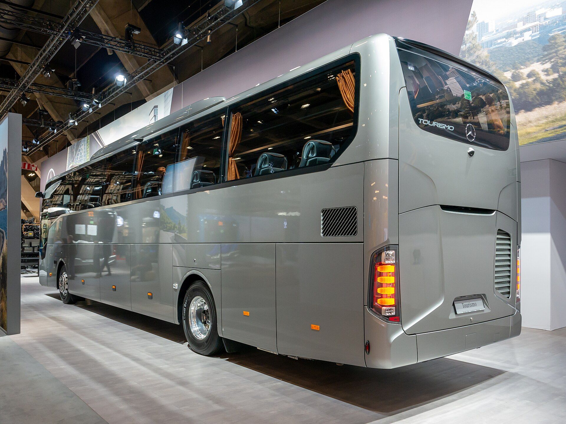 Silver Mercedes-Benz Tourismo M/2 high-deck touring coach on an exhibition stand, seen from the rear quarter