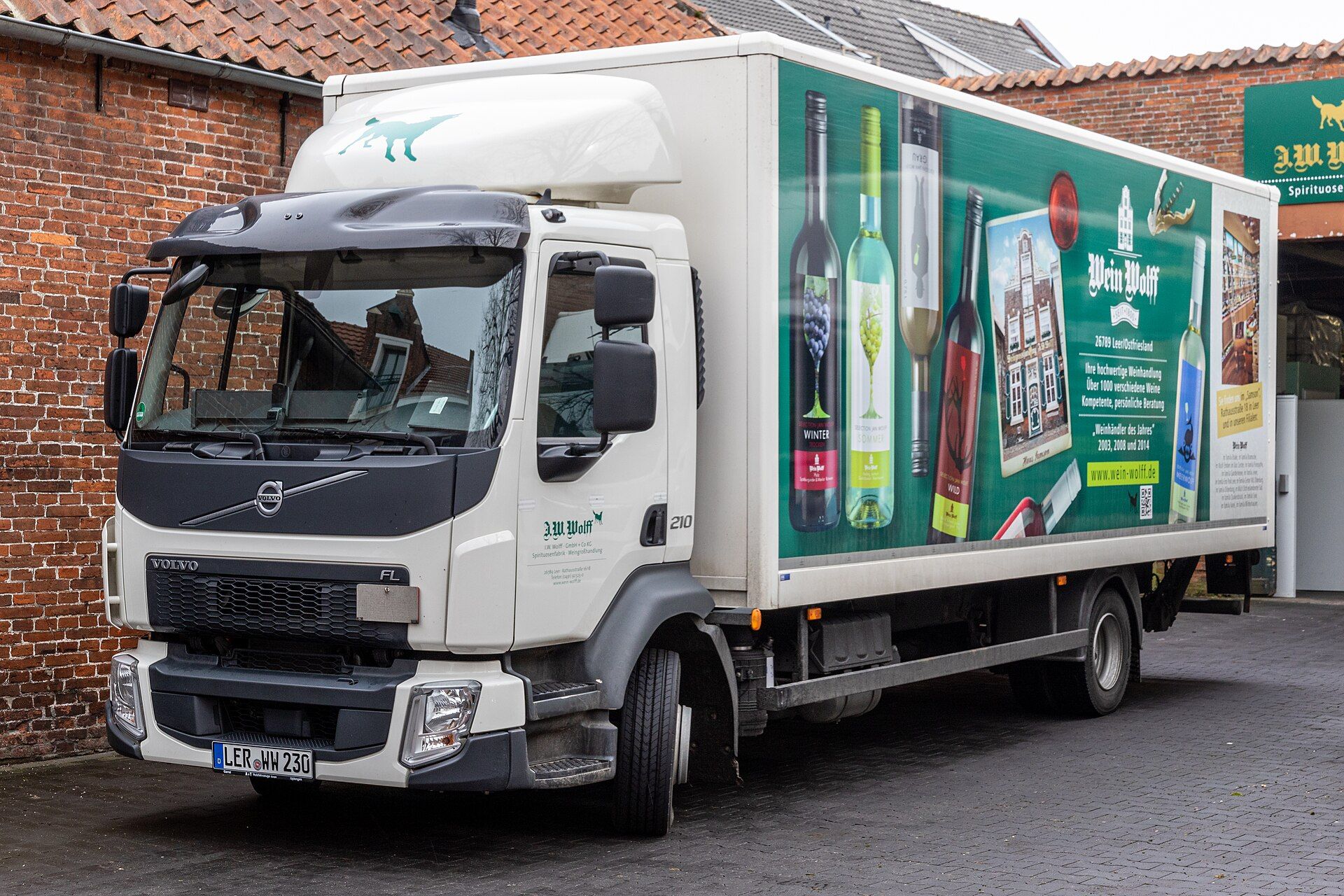 White Volvo FL 210 two-axle rigid with a box body and tail lift, parked at a wine merchant's premises in Leer, Germany